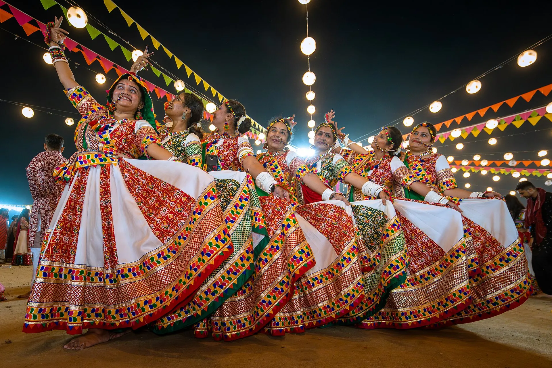 Garba dancers in colourful embroidered skirts performing at a Navratri night celebration