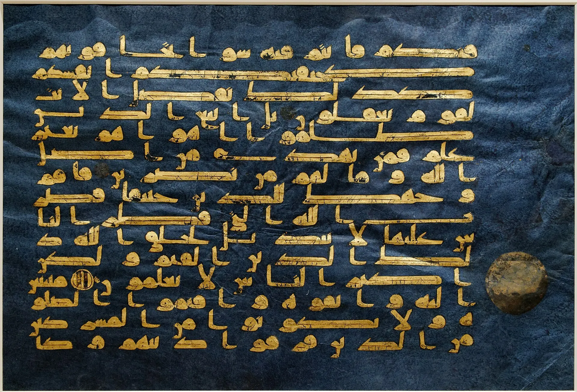 Gold Kufic Arabic calligraphy on a deep blue vellum page of the Blue Quran manuscript